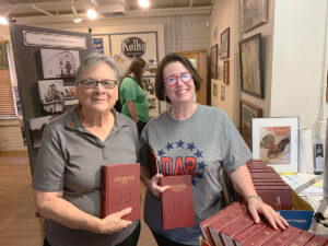GACC - Carol Schlueter, left, accepts the donation of early church records from Kay Alpaugh.